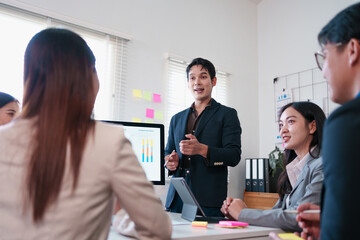 Business team meeting with sales performance chart, diverse professionals discussing data analysis, teamwork, and strategy planning in modern office environment