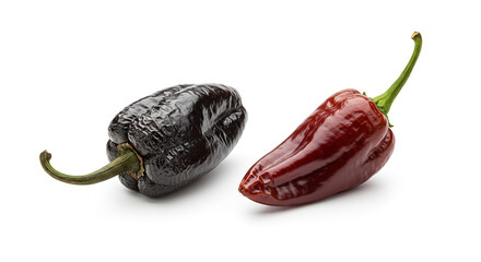 Two peppers on a white background, one dark and wrinkled, the other smooth and a deep red color