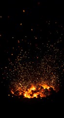 Fiery sparks explode in a dark background. The fiery show emits light. The fire gives a feeling of warmth and excitement