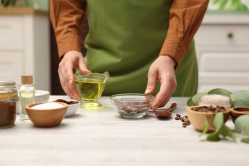 Woman making natural body scrub at white wooden table, closeup