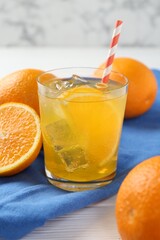 Refreshing soda water with orange slice in glass and fresh fruits on white wooden table, closeup