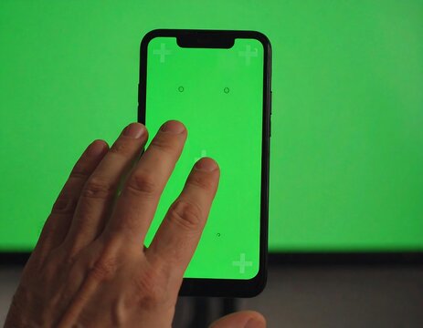Hand touching smartphone's green screen