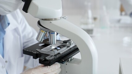 White gloved hands of scientist professional adjusting a microscope in a bright laboratory, emphasizing precision and focus in scientific research. Medicine, healthcare and science concept