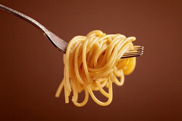 A forkful of cooked spaghetti against a brown background