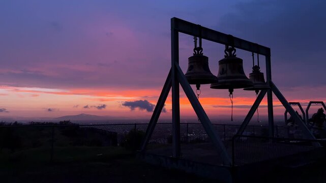 tres campanas al amanecer o al anochecer con el paisaje al fondo hermoso cielo colorido campanario con campanas de bronce armonia y sonido de tranquilidad en la ciudad colgantes en estructura templo