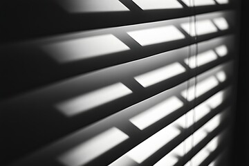 Dramatic light patterns created by modern blinds cast sharp shadows on sleek surfaces