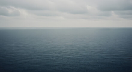 Obraz premium 静かな海 灰色空の下 穏やかに波打つ水面. AI Generated