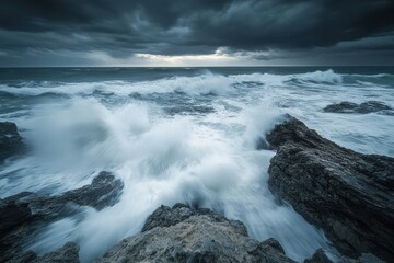 Obraz premium Powerful ocean waves crash against rugged rocks under a dramatic stormy sky