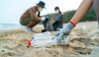 Volunteers with gloves and masks picking up plastic bottles on a sandy beach, dedicated to environmental conservation and ocean cleanup efforts