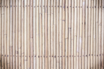 Bamboo wood fence with nail patterns on brown wall background
