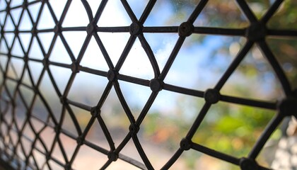 Fototapeta premium Close Up Of A Diamond Patterned Window Lattice With Blurred Background And Sunlight