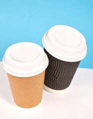 Two disposable coffee cups, one light brown and one dark brown, on a white surface against a light blue background
