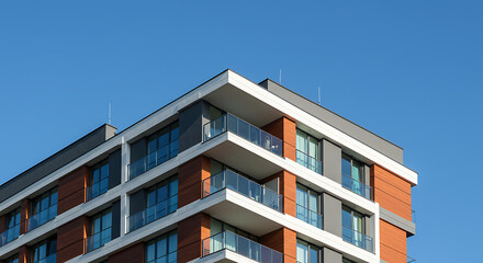 Obraz premium Modern residential apartment building exterior with blue sky — real estate and architecture concept