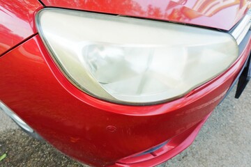 Car lights are dim or fading due to age.  headlamp that look dull. Close-up of yellowed, foggy, eyesore car headlights.   © Fauzi