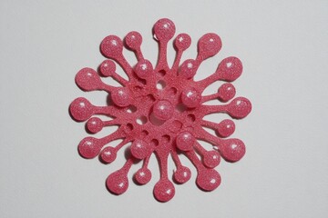 Pink, textured, circular design, resembling a virus or flower
