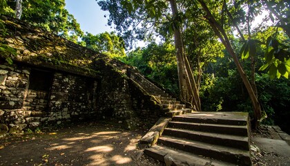 Ancient stone structures nestled within a lush jungle setting, showcasing weathered stonework and a stairway leading into the depths of the forest.