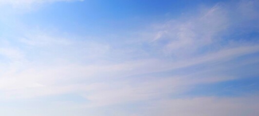 Panorama view of bright blue sky with fluffy white clouds on a clear sunny day. Sky panorama clear blue with white clouds in spring. Cloudscape. Clear blue sky, bright spring, wallpaper landscape.