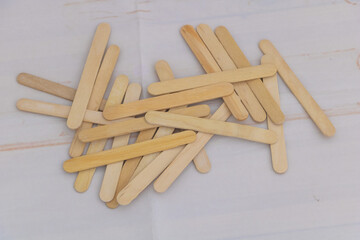 Wooden craft sticks scattered on white background for DIY and creative projects