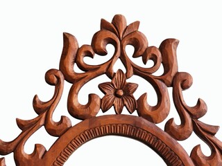 The white background image in the picture is a wooden frame decorated with carved patterns of brown leaves and flowers. It is an oval glass frame with a beautiful pattern used to decorate the house.