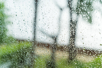 Clear droplets of cold rain on a glass window create a winter texture pattern