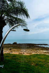 Tropical beach paradise outdoor shower with palm trees and sea views