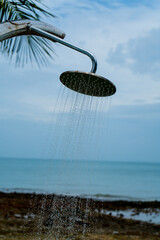 Tropical beach paradise outdoor shower with palm trees and sea views