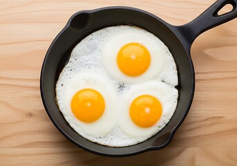Three Fried Eggs in Cast Iron Skillet on Wooden Tabletop.