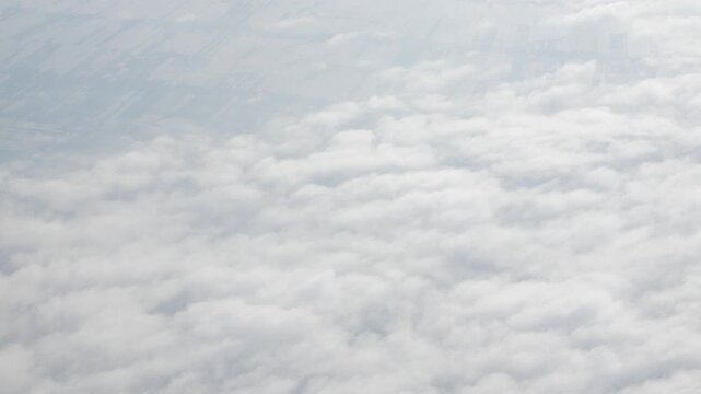 Aerial view above the clouds and sky inspiration concept in cinematic breathtaking aerial flying over white fluffy cloudscape in high altitude sky with fresh clean air and blue skies on background.