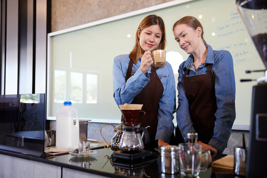young barista woman making fresh coffee from machine and checking quality in the cafe