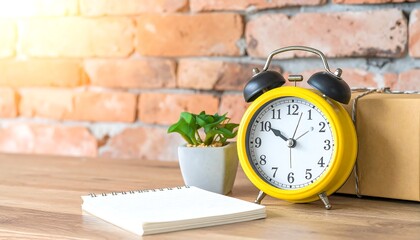 A vibrant yellow alarm clock rests on a wooden desk in the morning sunlight, next to a notepad, symbolizing a productive start to the day