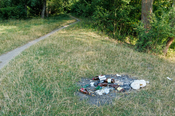 Garbage and burnt litter dumped in forest clearing