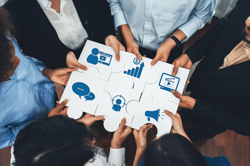This image captures a diverse team collaborating on a marketing strategy, holding puzzle pieces that symbolize important business concepts and data insights for growth. Amity
