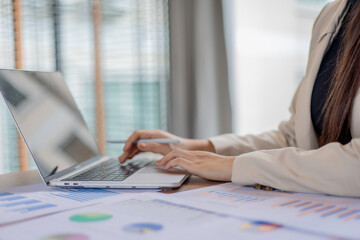 Elderly businessman in office, seated at desk reviewing blueprints and documents, showing leadership, concentration, and professional management expertise.
