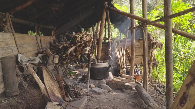Traditional palm wine distillery in rural Flores, Indonesia, producing arak or sopi alcohol from fermented sap over an open fire
