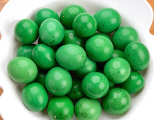 A white bowl overflows with glossy, green eggs