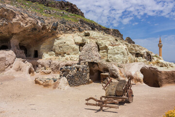 View on wooden cart with hay near cave walls of underground city of Kayasehir near Nevsehir castle, Turkey. Rock Town Kayasehir