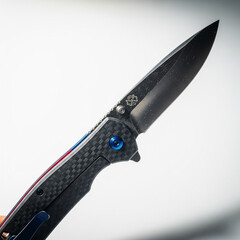 Obraz premium Folding Pocket Knife Macro: Dark Commercial Photo, White Background