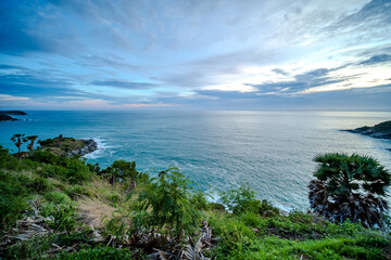 rocky shore and a sandy beach on the island with blue-green sea and clear blue sky