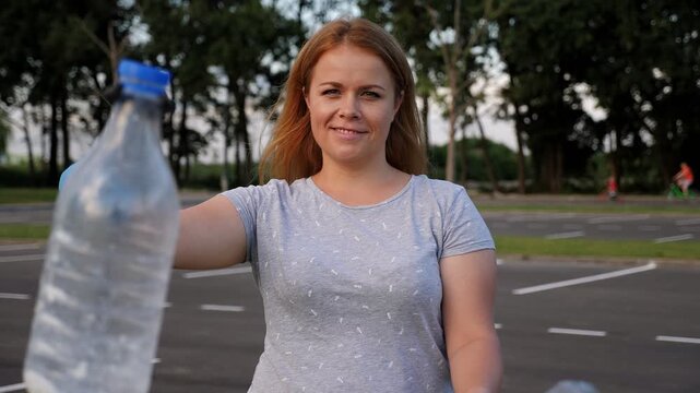Portrait of a female volunteer holding tongs for picking up plastic garbage. The concept of volunteering for environmental protection through garbage collection.