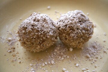 Traditional homemade plum dumplings served on yellow plate, close-up view.