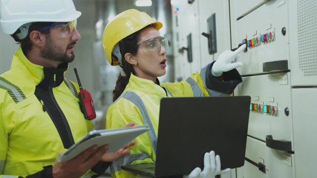 HVAC System Control Check Industry experts checking the control systems for a large building's water cooling tower and air chilling units.