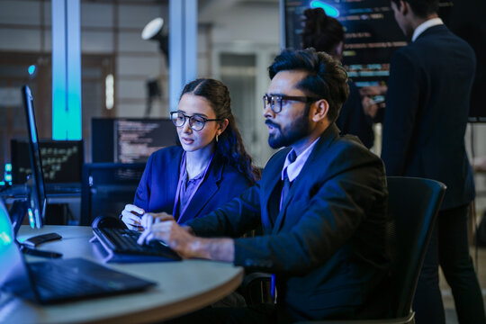 A diverse team of AI developers shares a successful moment in the office. A female programmer smiles as they review the positive results of a complex machine learning algorithm. - Powered by Adobe