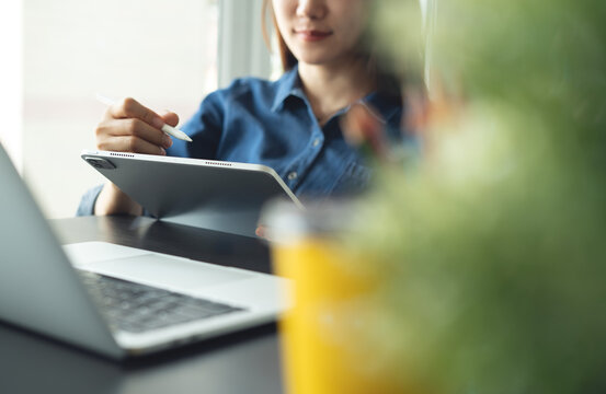 Architecture and interior design concept. Asian business woman architect using digital tablet for creating interior design project in studio office. Freelancer woman working in office, close up