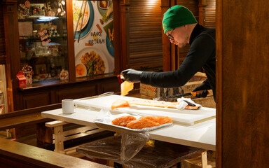 サーモンを切り分ける男性