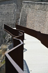 Modern tourist walkway with railing along the walls of the old castle in Alicante, combining history and modernity