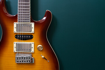 Electric guitar on green table background, close up music concept