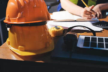 Closeup of team of industrial engineers meeting analyze machinery blueprints consult project on table in manufacturing factory. Working in manufacturing plant or production plant.