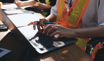 Closeup of team of industrial engineers meeting analyze machinery blueprints consult project on table in manufacturing factory. Working in manufacturing plant or production plant.