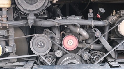Detailed view of an automotive engine showing pulleys, belts, and mechanical components, highlighting industrial design and mechanical engineering.

