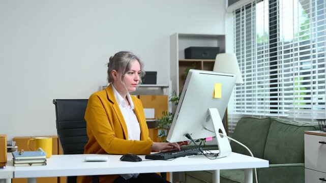 Young business owner woman prepare parcel box and standing check online orders for deliver to customer on tablet, laptop Shopping Online concept.